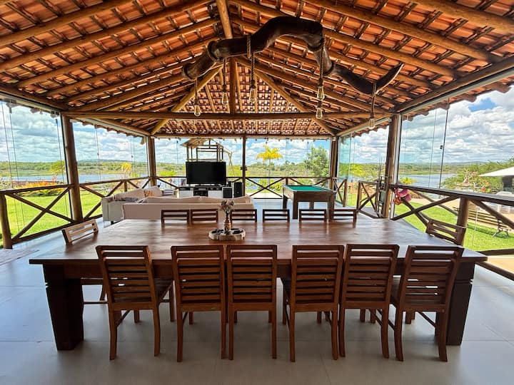 Mesa grande na varanda com vista para o rio