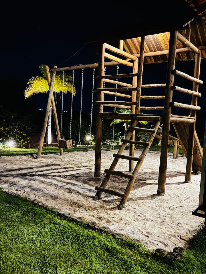 Parque infantil de madeira iluminado à noite