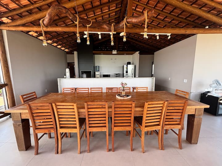 Mesa de jantar longa com cozinha ao fundo